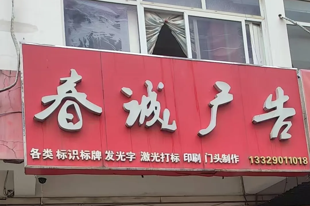 春诚激光打标合肥包河区实体门店门头实拍 · 红色招牌「春诚广告」标明各类标识标牌、发光字、激光打标、印刷、门头制作，可上门看样